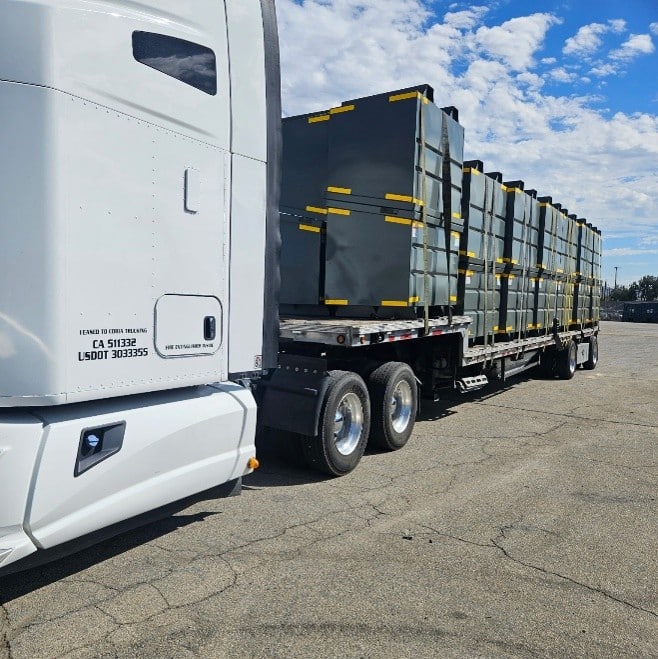 Flatbed trailer loaded with steel containers, a Pez Logistics freight shipment